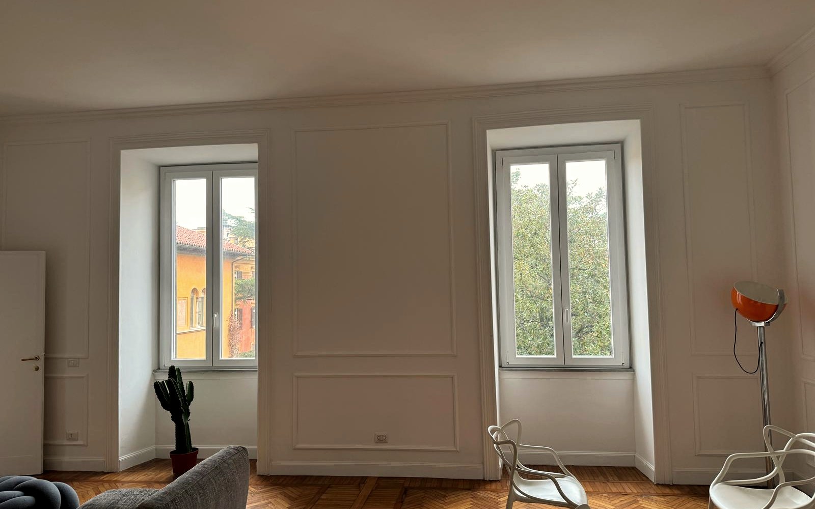 Salone con boiserie, nuovi serramenti e parquet a spina